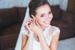 Bride-putting-earring-on-scaled